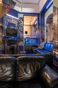 un bar con muebles de cuero y un hombre sentado en un sofá en Sundancer Backpackers Hostel, en Fremantle
