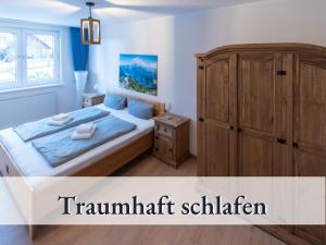 ブラウンラーゲにあるHaus an der Skiwieseのベッドルーム1室(ベッド1台付)、木製キャビネットが備わります。