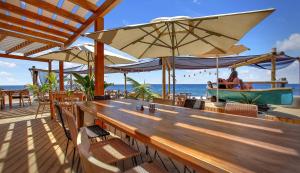 ein Restaurant mit einem Tisch und einem Boot am Strand in der Unterkunft Luxury House Paraiso Del Palm Mar in Palm-mar