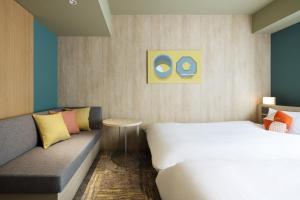 una camera d'albergo con letto e divano di OMO5 Kanazawa Katamachi by Hoshino Resorts a Kanazawa