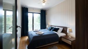 ヴィスワにあるApartamenty Sun & Snow Tęczowe Wzgórzeのベッドルーム1室(青い毛布、窓付)