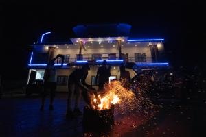 un grupo de personas jugando alrededor de un fuego por la noche en Namasthe Thekkady en Thekkadi
