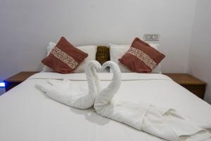 Dos cisnes haciendo forma de corazón en una cama en Namasthe Thekkady en Thekkadi