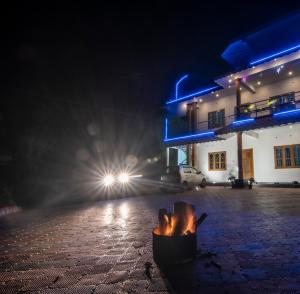 un foyer extérieur en face d'un bâtiment la nuit dans l'établissement Namasthe Thekkady, à Thekkady