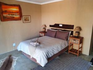 um quarto com uma cama grande e 2 mesas de cabeceira em Nyani Lodge Dinokeng em Pretoria