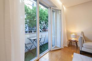 a room with a balcony with a table and a window at FLH Gulbenkian Apartment with Balcony in Lisbon