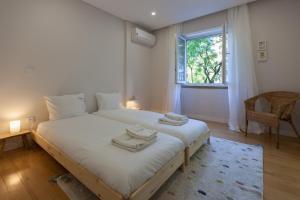 a bedroom with a large white bed with towels on it at FLH Gulbenkian Apartment with Balcony in Lisbon