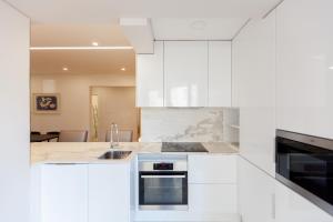 a kitchen with white cabinets and a sink at FLH Gulbenkian Apartment with Balcony in Lisbon