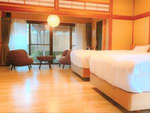 a bedroom with two beds and a wooden floor at KOUBOUNOYU IKONASOU in Shizuoka