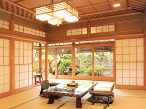 静岡市にあるKOUBOUNOYU IKONASOUのテーブルと椅子、窓が備わる客室です。