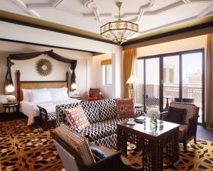 a living room filled with furniture and a large window at Jumeirah Al Qasr in Dubai