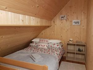 ein Schlafzimmer mit einem Bett in einer Holzhütte in der Unterkunft Gorska Vila in Mrkopalj