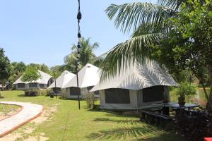 a row of tents in a yard with grass and trees at Inap Dusun Fraser Valley Kuala Kubu Bharu in Kuala Kubu Baharu