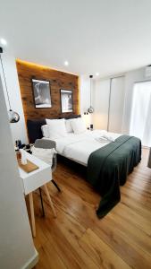 ein Schlafzimmer mit einem großen Bett und einem Tisch in der Unterkunft Appart Dolce Vita à Praia in Praia