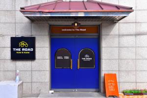 a blue door of a building with a sign on it at The Road Hotel in Seoul