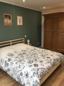 - une chambre dotée d'un lit avec une couverture bleue et blanche dans l'établissement Charmant gîte à la ferme situé à 20 min de la mer, à Hermelinghen