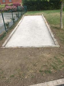 een betonnen helling in een tuin met een hek bij Charmant gîte à la ferme situé à 20 min de la mer in Hermelinghen