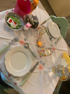 Rocca MassimaにあるIl Borgo Anticoの白いテーブルクロスに皿や調理器具をかけたテーブル