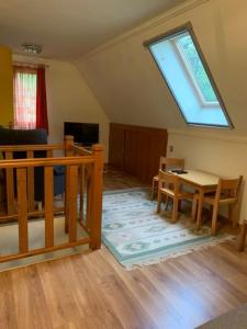 a living room with a table and a window at Gyöngyvirág Vendégház in Noszvaj