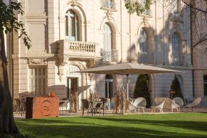 uma mesa e cadeiras com um guarda-sol em frente a um edifício em Domaine de Biar em Montpellier