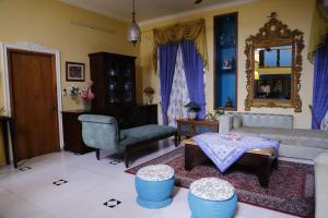 a living room with a couch and a chair at Aura Homestay Royal Villa in Jaipur