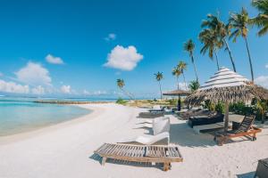 a beach with chairs and umbrellas and the ocean at The Bilimbi Guesthouse & Inn in Huraa