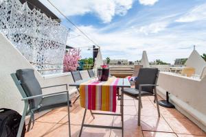 patio ze stołem i krzesłami na balkonie w obiekcie Cocooning w Cap d'Agde