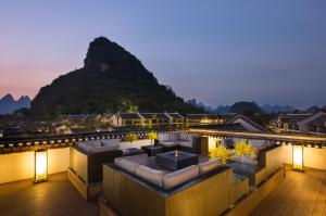a hotel rooftop with a mountain in the background at Banyan Tree Yangshuo in Yangshuo