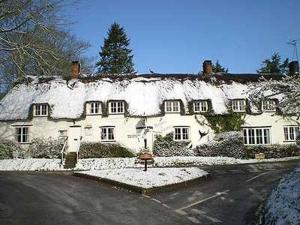 a large white house with snow on the roof at Brace of Pheasants in Alton Pancras