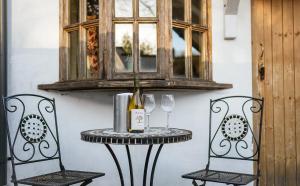 un tavolo con una bottiglia di vino e due bicchieri di Brace of Pheasants ad Alton Pancras