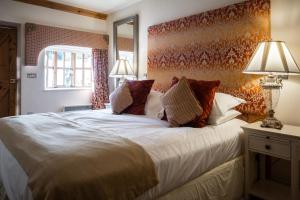 a bedroom with a large white bed with pillows at Brace of Pheasants in Alton Pancras