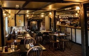 Alton PancrasにあるBrace of Pheasantsのテーブルと椅子のあるレストラン、バー