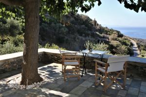 a table and chairs on a patio with a tree at Sea view studio in Batsi