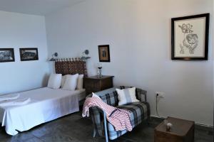 una camera d'albergo con letto e sedia di Sea view studio a Mpatsi (Batsi)
