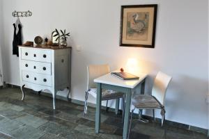 a room with a table and chairs and a dresser at Sea view studio in Batsi