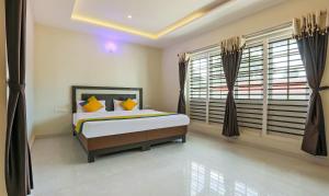 - une chambre avec un lit et une grande fenêtre dans l'établissement Itsy By Treebo - Kottaram Residency, à Ooty