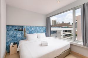 a bedroom with a large bed and a large window at Metz Pratunam in Bangkok