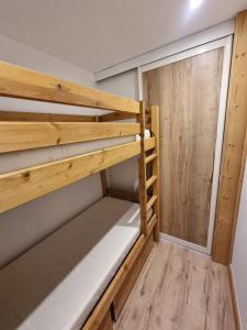 a bunk bed in a small room with a window at Le 1888 Val d'Isère in La Daille