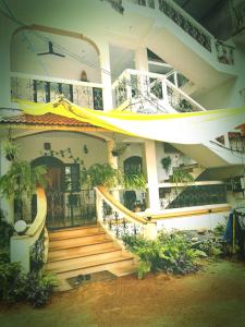 a house with a wooden staircase in front of it at TGI Guest Houses in Calangute