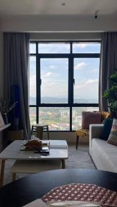 uma sala de estar com uma mesa e uma grande janela em Hill10 Residence, I-City (above DoubleTree Hotel) em Shah Alam