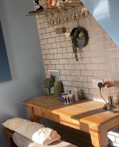 a room with a wooden table with a brick wall at The Sail Loft in Kingsbridge