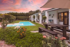a backyard with a swimming pool and a house at Sixteen Guesthouse on Main in Hermanus