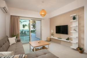 Una sala de estar con un sofá y un televisor. en Sea Homes Villas-Villa Sylvia, en Kiotari