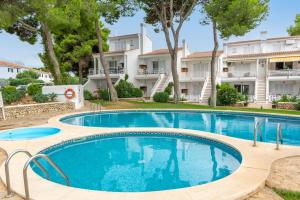 a swimming pool in front of a building at Edisol 29 -Villa Pilar 2- in Port d'Addaia