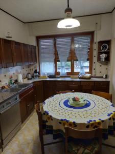 - une cuisine avec une table et une plaque de cuisson dans l'établissement Cà dai nonni sul Lago d Orta, à San Maurizio dʼOpaglio