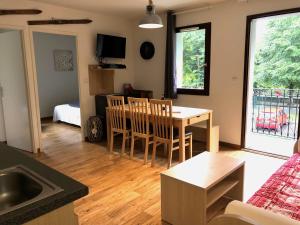 a kitchen and living room with a table and chairs at T3 Raph & Gab's 3 Etoiles Jardins de Ramel WIFI Lave Linge in Luchon