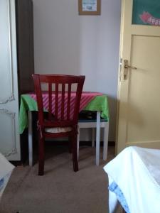 une chaise en bois dans une chambre avec une table dans l'établissement Old Guest House 1964, à Žabljak