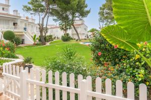 a white picket fence in front of a yard at Edisol 29 -Villa Pilar 2- in Port d'Addaia