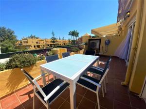 - Balcón con mesa blanca y sillas en Apartamento Dúplex Los Cartujanos I, en Marbella