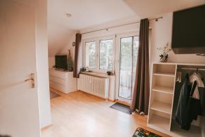 a living room with a large window and wooden floors at Ferienwohnung Seeblick Wadee in Radolfzell am Bodensee